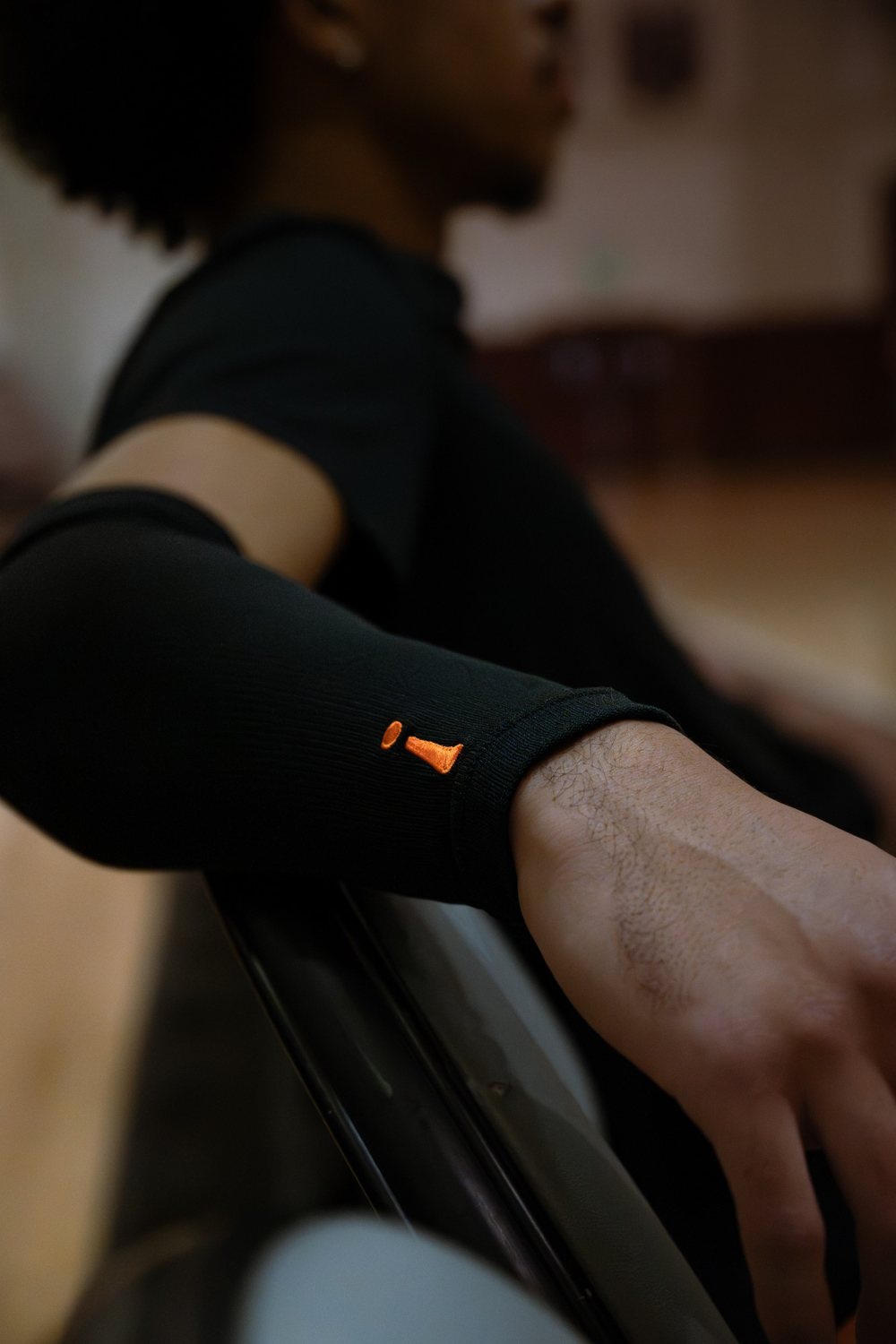 Close-up of the black Incrediwear arm sleeve and its orange logo