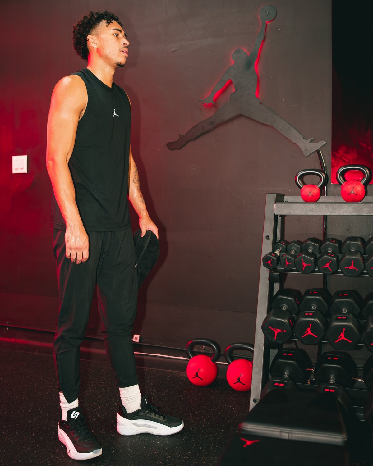 Jayo beside the Jumpman wall and Jordan kettlebells at the launch