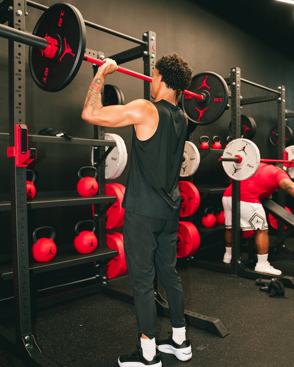 Jayo in a front rack with a red Jordan Strength barbell
