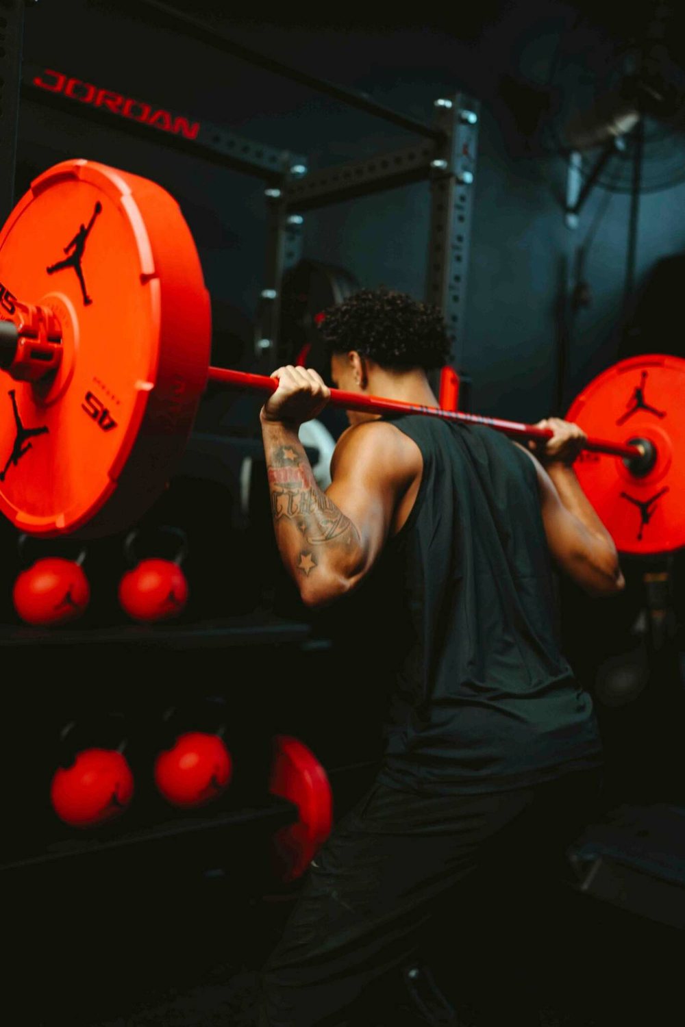 Jayo squatting with red Jordan Strength plates