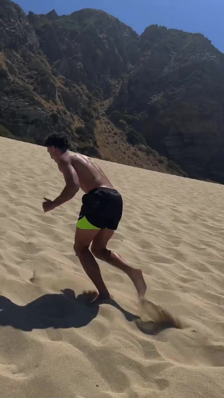 Jayo sprinting up a sand dune above the Malibu coast